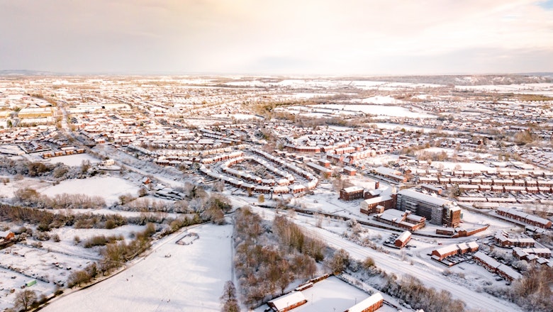 Aerial view of snow covered homes in the suburbs of England