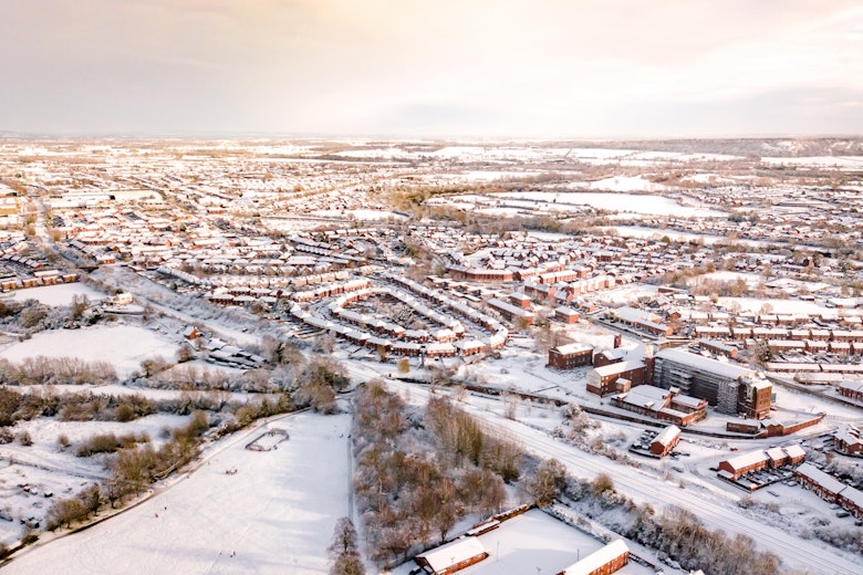 Aerial view of snow covered homes in the suburbs of England